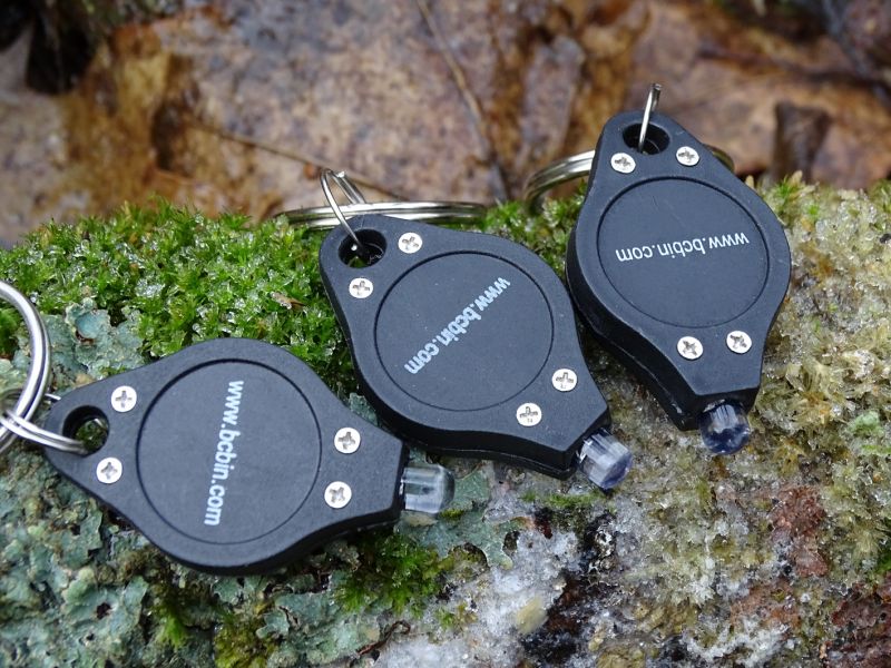 1Svítilny svým tvarem tak trošku připomínají žeton do nákupního vozíku. Délka svítilny je 40 mm, šířka 23 mm a výška 7 mm. Hmotnost pak nepatrných 5 gramů vč. baterie. Doporučuji hned po zakoupení odstranit malý mezikroužek pro zavěšení. A ten velký přímo protáhnout otvorem v těle svítilny – zajistíte takto svítilnu mnohem lépe.