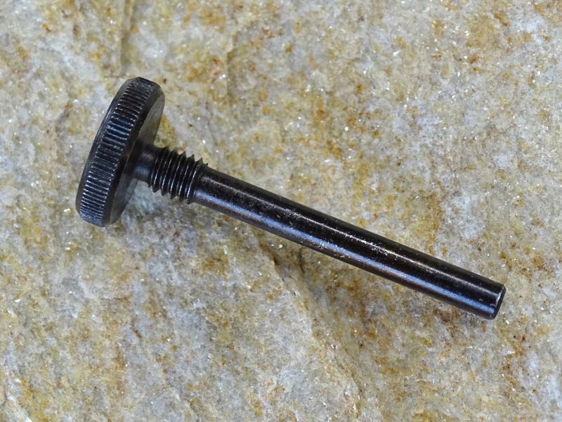 Pohled na ocelovou vyrážecí tyčinku. Je osazena velkou hlavou pro snazší zašroubování a vyšroubování.