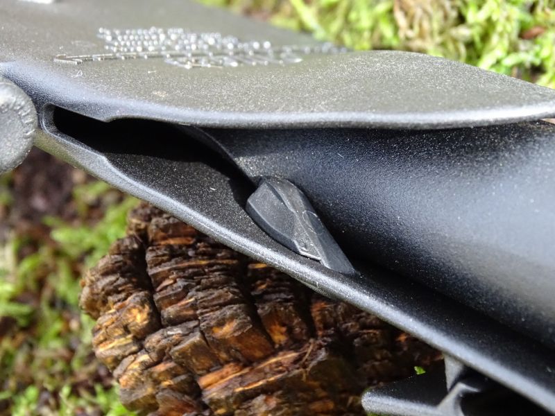 I „zámek“ držící nůž v pouzdře pracuje na shodném principu. Plastový ozub za který se zachytí ocelová čepel nože. Vysunutí proběhne pouze jednoduchým odtlačením ozubu palcem ruky.