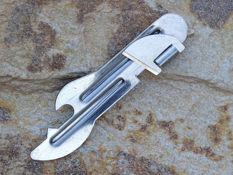 A ještě jeden otevírák konzerv s integrovaným otevírákem korunkových uzávěrů. I když vypadá zajímavě, poměrně špatně se ovládá. Jeho délka je 80 mm a hmotnost 10 gramů.