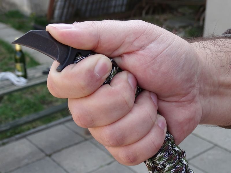 Nůž je opravdu velmi povedeně tvarován přesně tak, aby i za pomoci rozepnutého para náramku dobře padl do ruky. Rýhování na hřbetu ocelové čepele, které plynule navazuje na polymerovou část nože (ta je také zdrsněna rýhováním) vytváří dokonalou oporu pro palec ruky a umožňuje tak vedení razantních vertikálně i horizontálně orientovaných řezných úderů. Ukazovák se pro změnu opírá o výrazný spodní ozub. Takto je vytvořen dokonalý a jistý úchop.