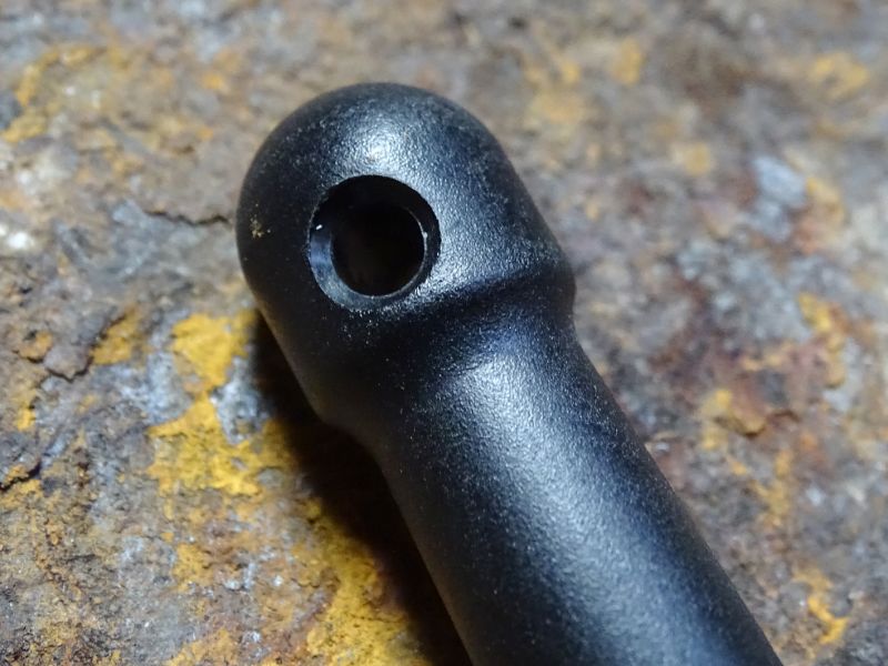 Kruhový otvor v hlavici rukojeti pro možné provlečení závěsné či pojistné šňůry.