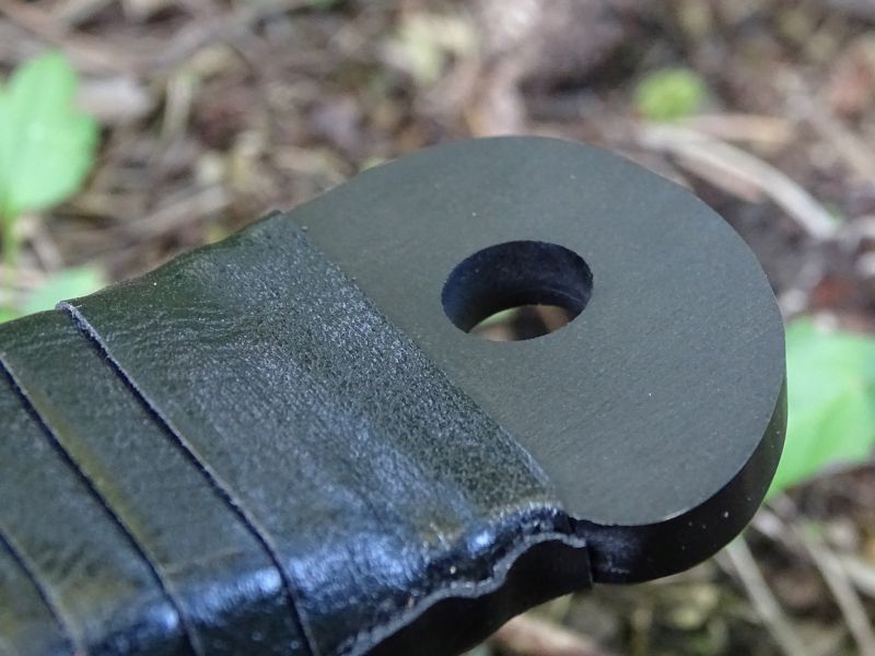 Nůž je zakončen masivní zaoblenou hlavicí s integrovaným otvorem kruhového průřezu.