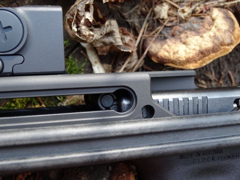 Okénko pro páku umožňující natažení pistole. Pěkně zde můžete vidět závěr pistole ve své přední poloze...