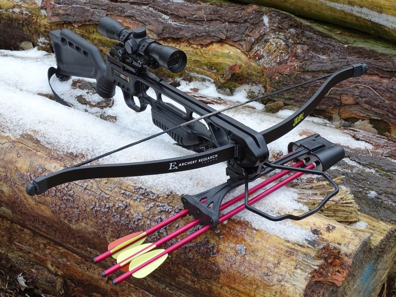 Celkový předoboční pohled na reflexní kuši JAGUAR osazenou optickým zaměřovačem, nosným popruhem a předním držákem šípů. Celý tento set zakoupíte v současnosti za přibližně 4000,- Kč včetně tří duralových šípů.