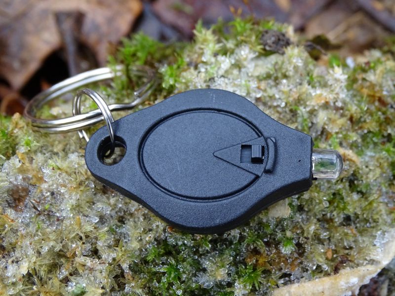 Pohled na svítilnu ze strany, kde je umístěn spínač pro zapnutí trvalého svícení. Pokud chcete svítit pouze po dobu stisku svítilny, stačí zatlačit palcem proti ukazováku na stěnách svítilny.