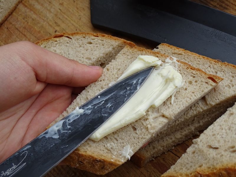I dýka vytažená z boty pěkně namazala čtvrtku chleba sýrem.