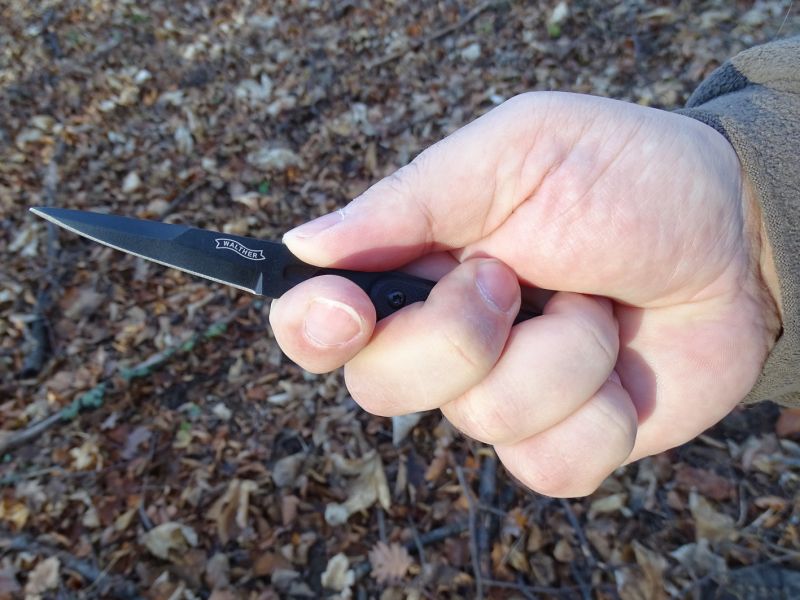 Jak uchopit takovýho drobka bude vždy jen na vás. Můžete třeba opřít ukazovák o nezúženou část čepele za falešným ostřím a použít pro běžné věci. Nebo ukazovák a palec opřít proti sobě do prohlubní na plochých stranách nožíku či ty samé prsty zatlačit do prohlubní na horní a spodní hraně nože a použít jej pro obranu/útok.