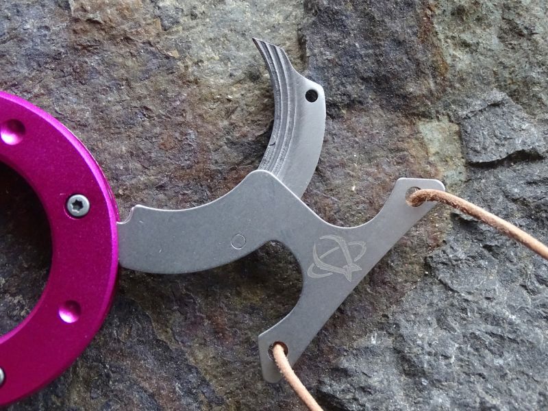 Páka díky níž dokáže nosič nože nůž bleskurychle otevřít a použít jej, je vyrobena z nerezové oceli a jsou v ní také integrovány otvory pro závěsnou šňůrku či třeba řetízek.