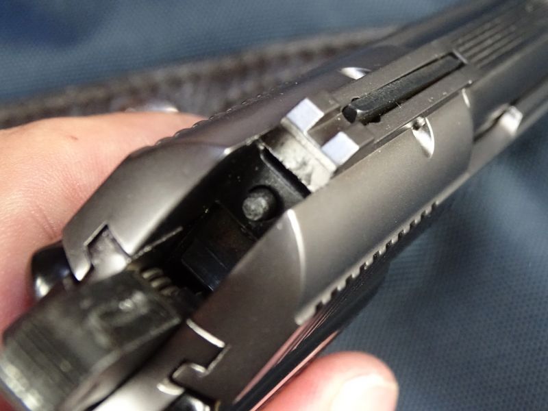 Pohled na natažený kohout a zadní čelo úderníku. Také si můžete všimnout až zbytečně masivního hledí.